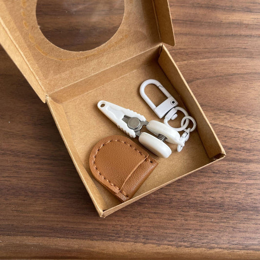 Brown Ultra-Portable Mini Precision Scissors Set - Compact 7cm Craft Snips with Safety Cap, Leather Sheath, and Keychain Hook for Travel and DIY.